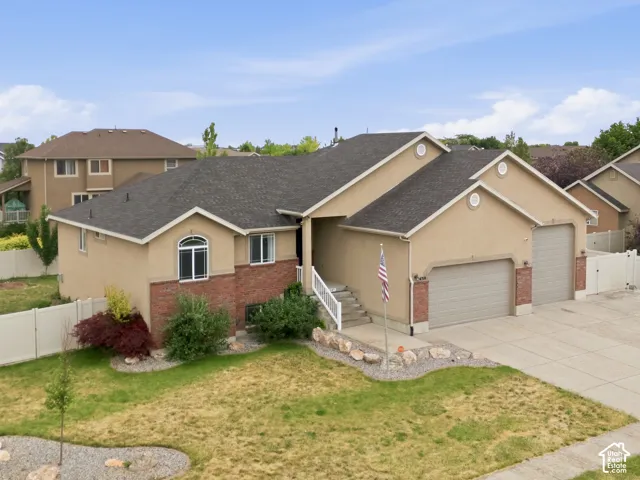 Stucco exterior with brick accents, multi-car garage, and a concrete driveway
