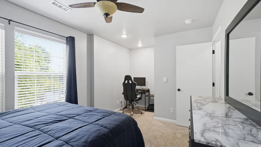 Carpeted bedroom featuring a ceiling fan with integrated lighting, recessed lighting, and a dedicated alcove