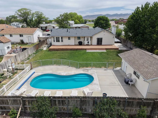 Backyard oasis featuring a kidney-shaped in-ground swimming pool with surrounding concrete patio