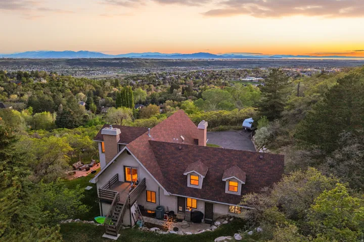 Multi-level residence with a wood deck and an expansive paved driveway