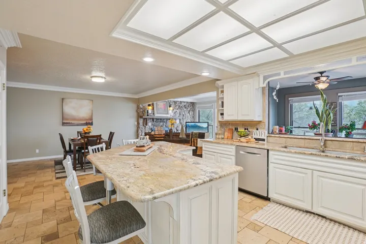 Kitchen island featuring a granite countertop and white cabinetry