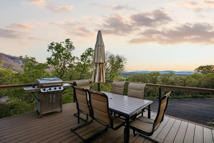 Spacious outdoor deck featuring wood-finish flooring, a full-length railing, and expansive mountain scenery