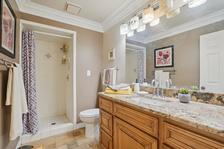 Vanity featuring a stone countertop, an integrated sink, and brushed nickel fixtures