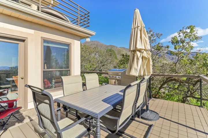 Expansive outdoor deck featuring wood-finish flooring, a full-height railing, and a built-in outdoor grill