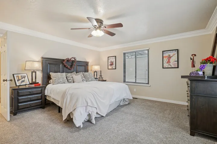 Spacious room featuring neutral wall tones and crown molding