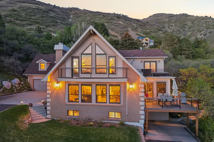 Multi-level residence featuring a brick facade with stone-look accents, prominent gabled roofline, and extensive window placements