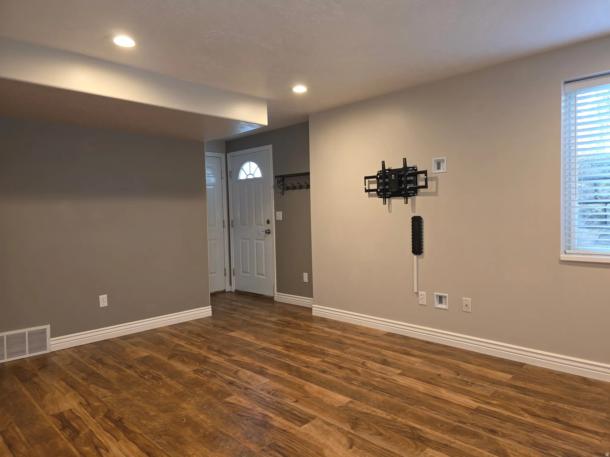 Spacious room featuring wood-finish flooring, recessed lighting, and a neutral paint palette