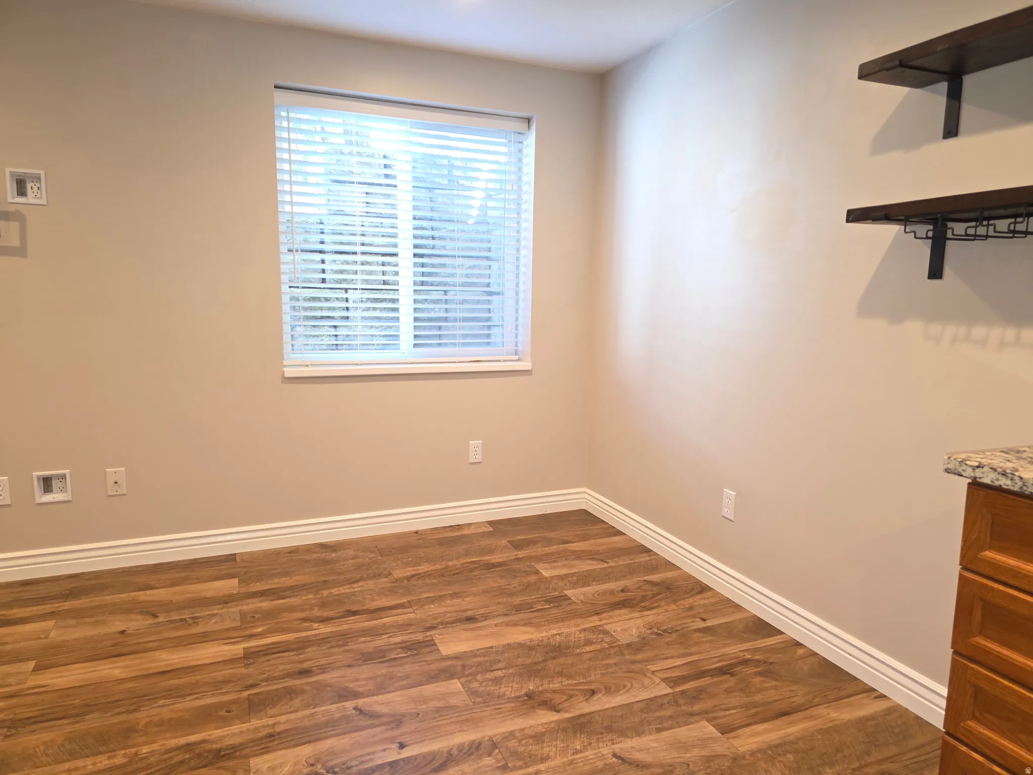Room featuring wood-finish flooring and neutral wall tones