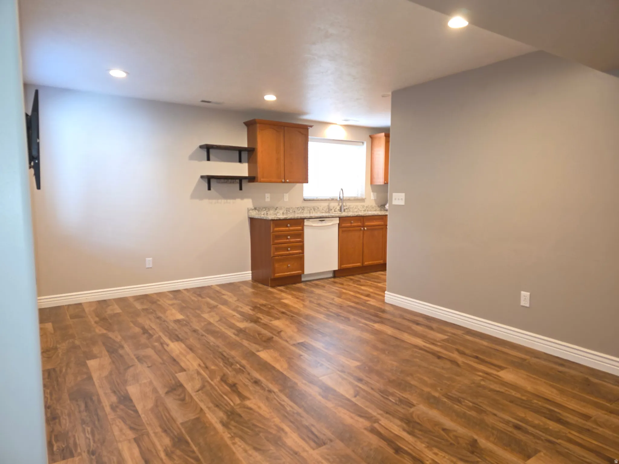 Open concept living space featuring wood-finish flooring, recessed lighting, and a neutral wall palette