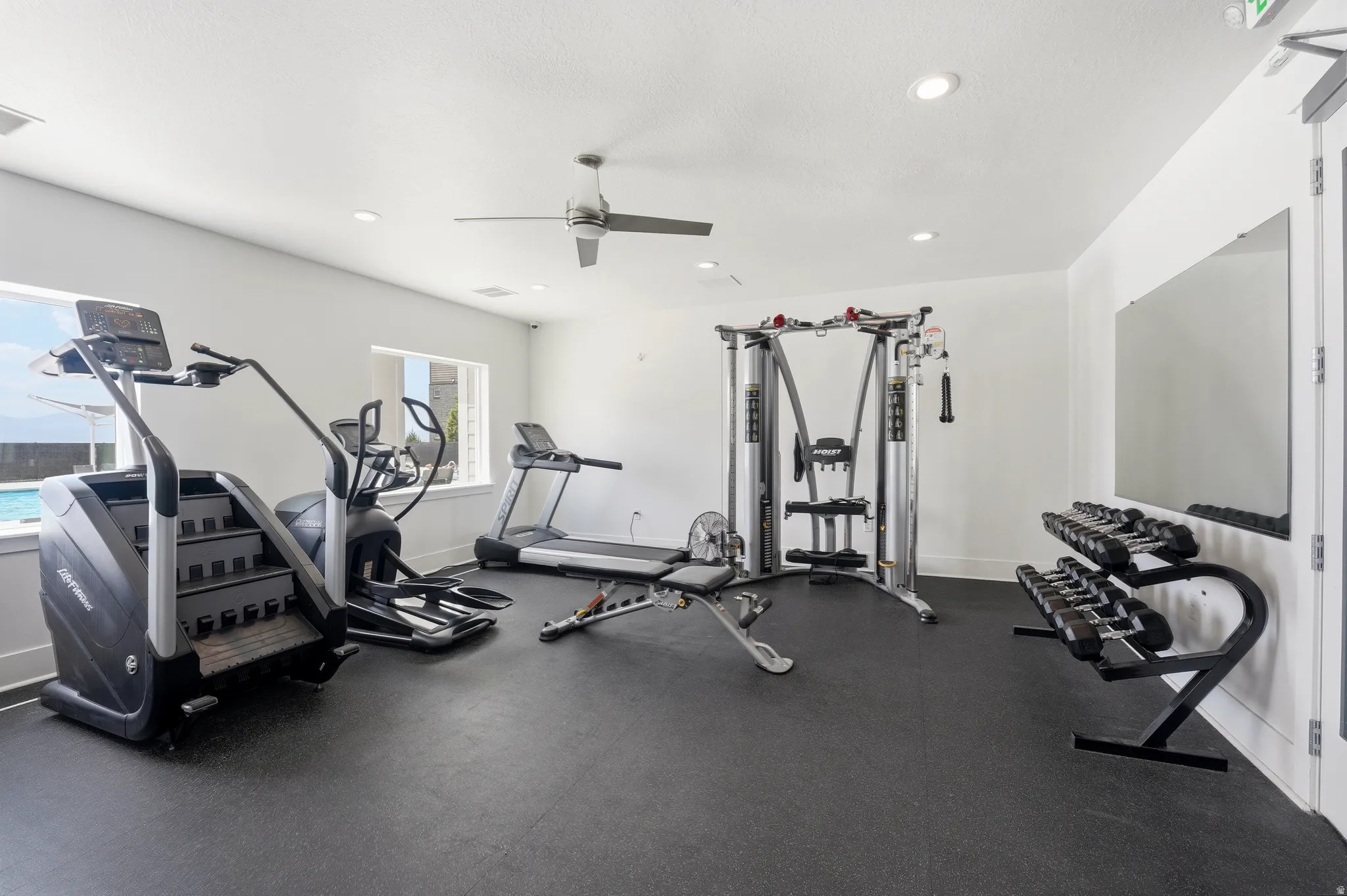 Dedicated fitness space featuring rubber flooring, a ceiling fan, and recessed lighting