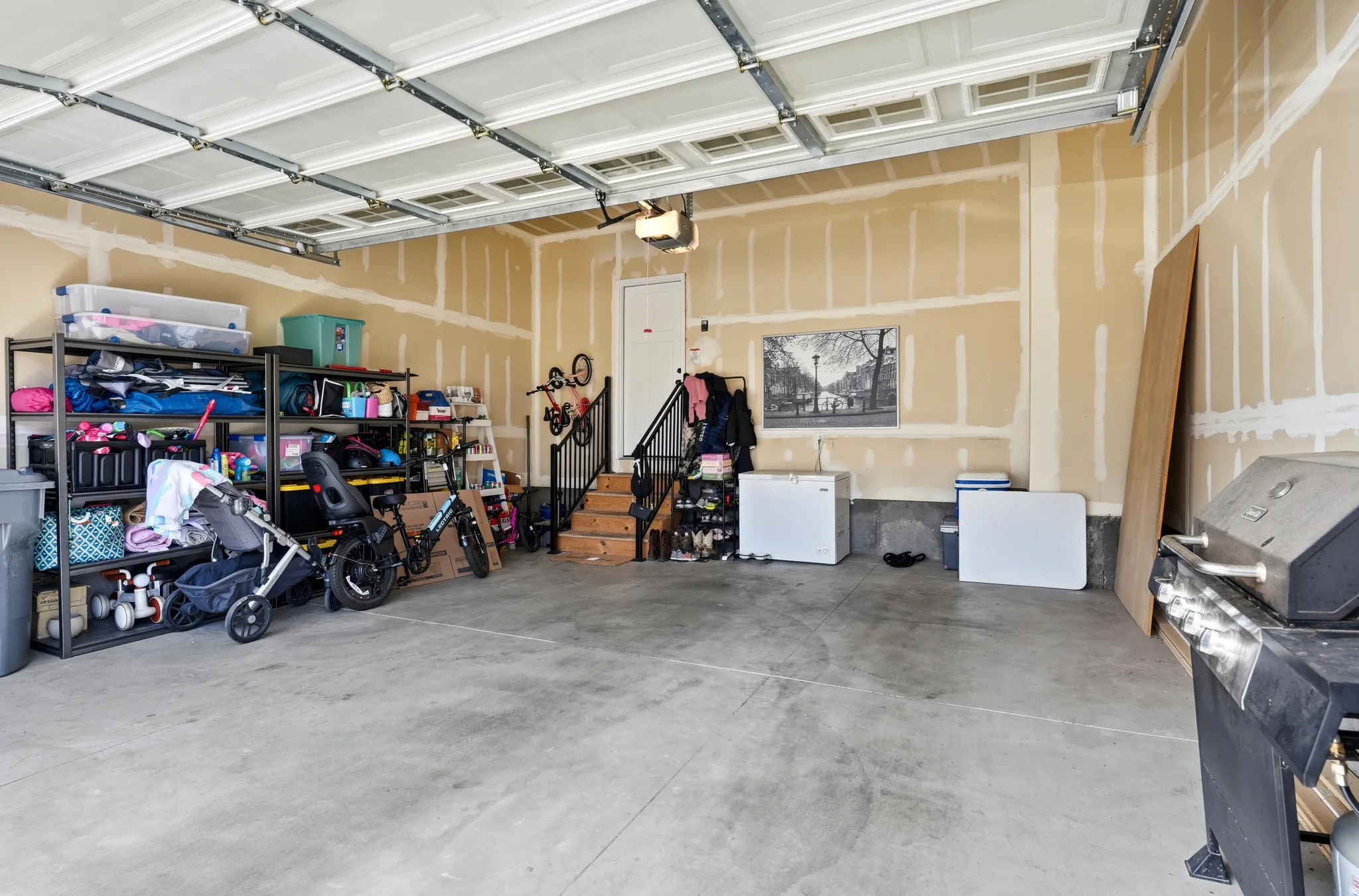 Spacious garage featuring a concrete floor, overhead door with track system, and unfinished wall surfaces