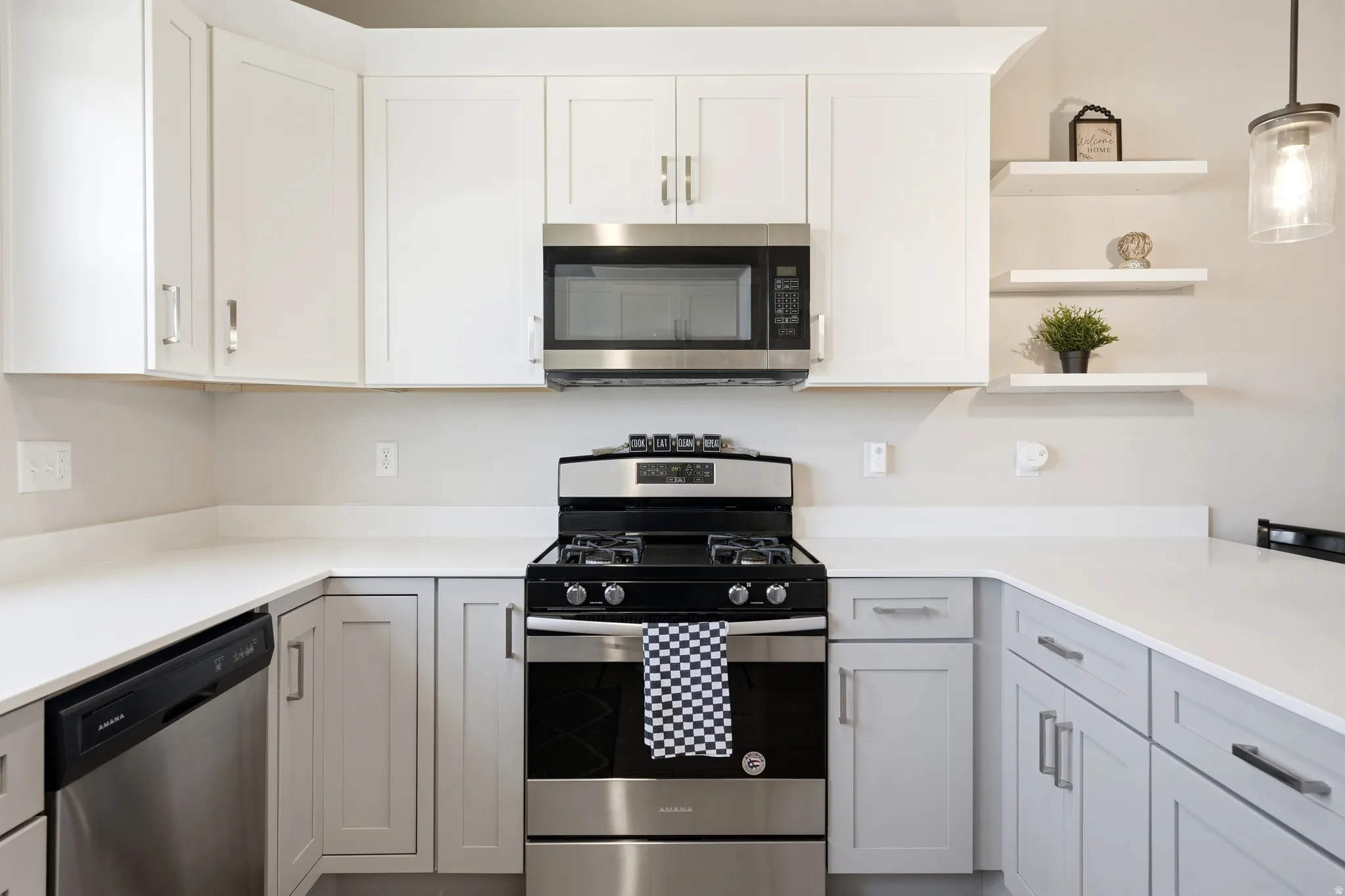Modern kitchen featuring white upper cabinetry and light gray lower cabinetry