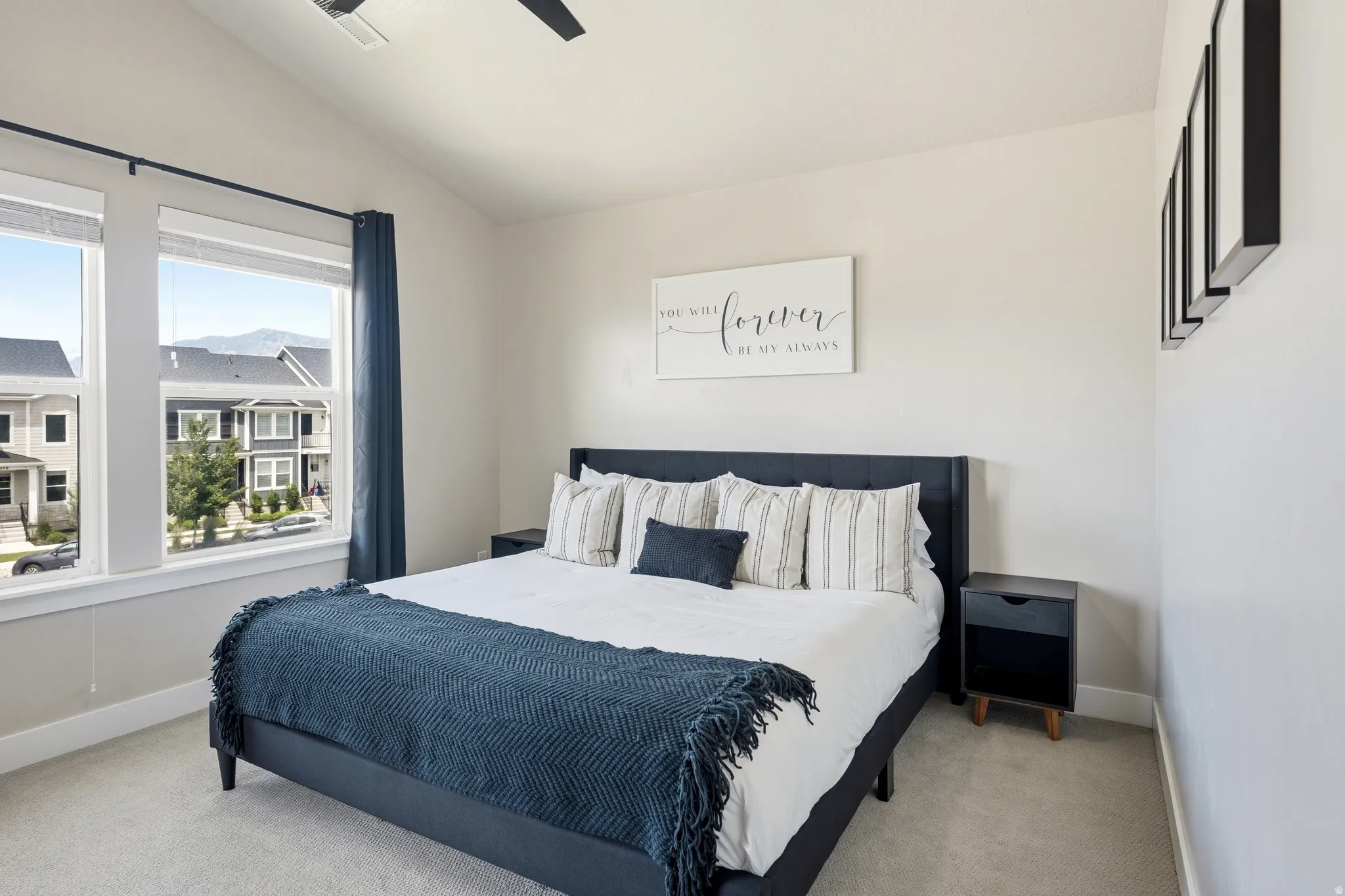 Carpeted room featuring a vaulted ceiling and a ceiling fan