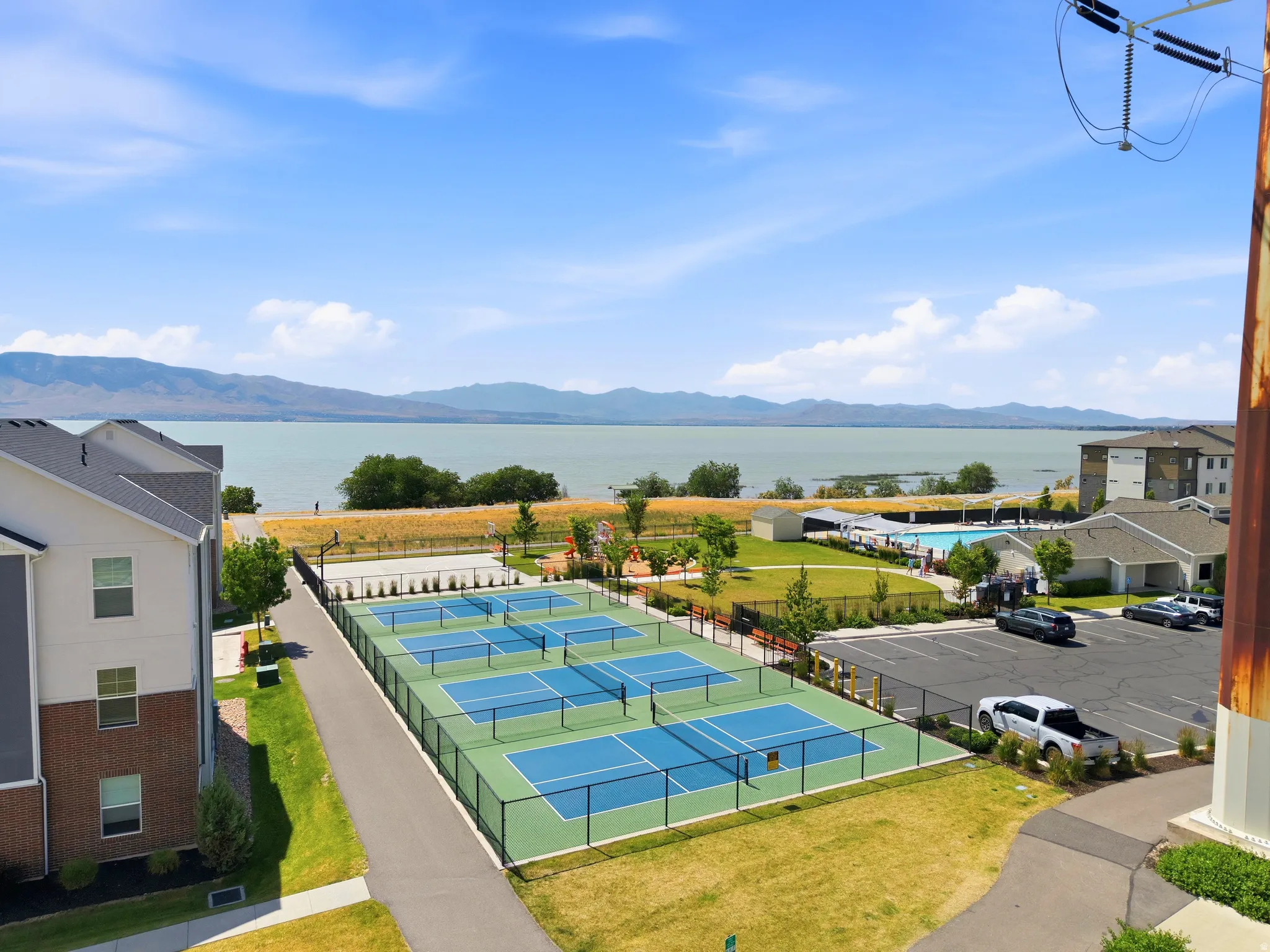 Expansive outdoor recreational area featuring multiple pickleball courts with black perimeter fencing
