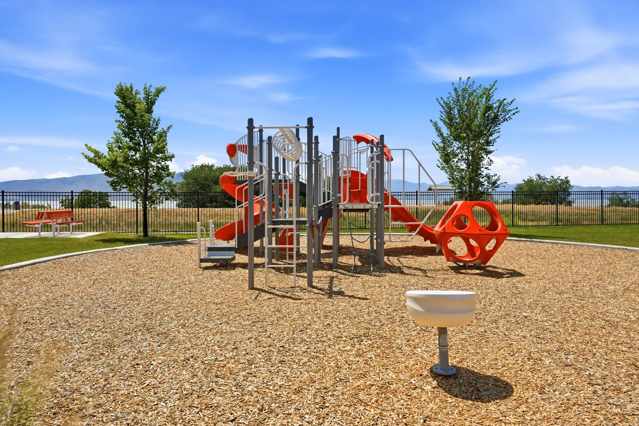 Outdoor recreational area featuring a multi-level playground structure with slides and climbing elements