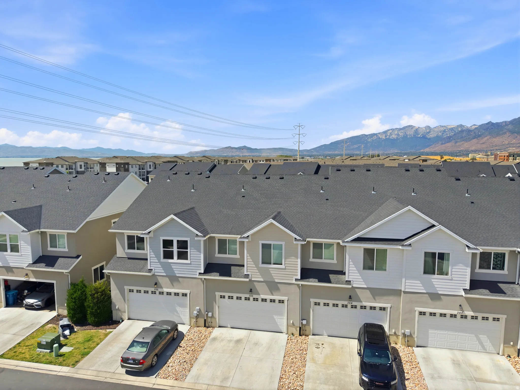 Contemporary townhome exteriors featuring light-toned siding and dark shingle roofing