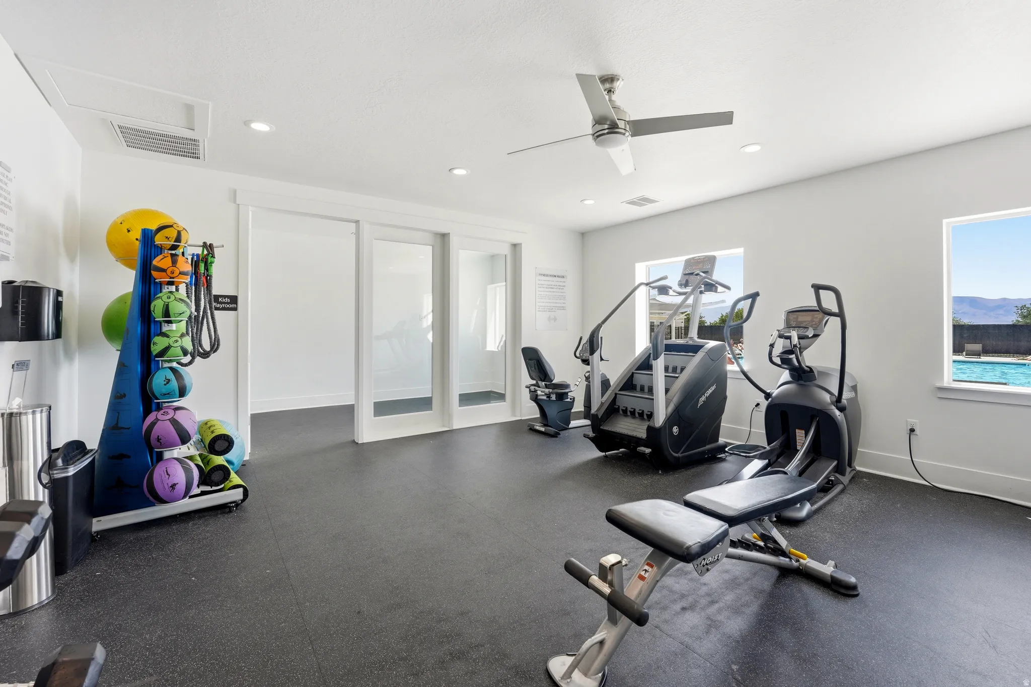 Dedicated fitness area featuring rubber flooring, recessed lighting, and a ceiling fan