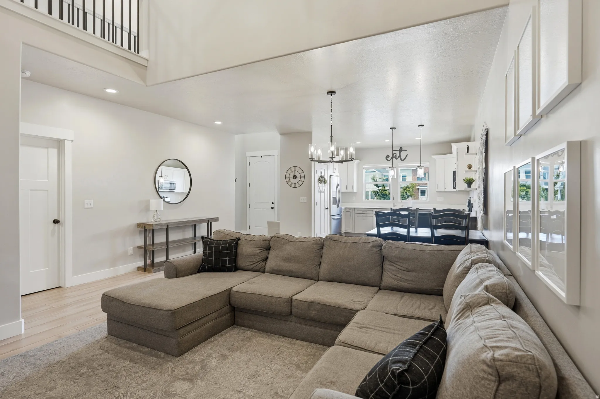 Open-concept living space featuring high ceilings, wood-finish flooring, and recessed lighting