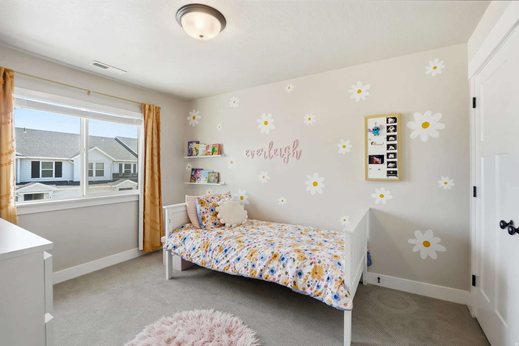 Bedroom featuring a window with natural light, neutral wall colors, wall-mounted shelving, and gray carpeting
