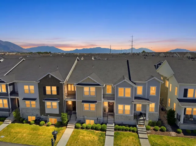 Modern townhome row featuring diverse exterior finishes including siding and stone accents