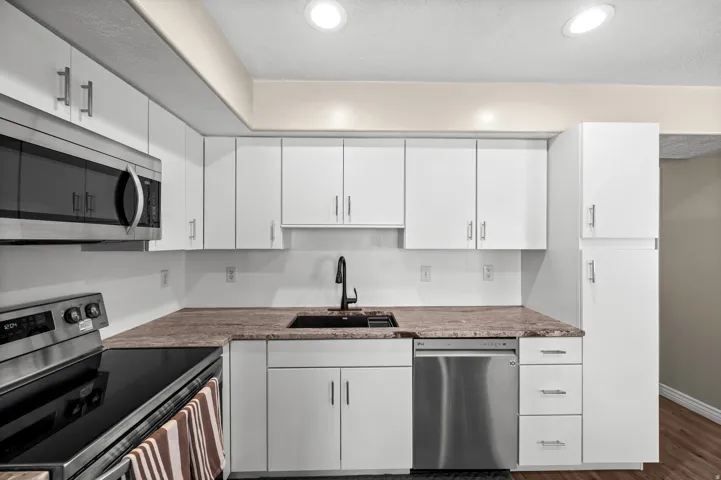 Modern kitchen with white cabinetry and stainless steel appliances