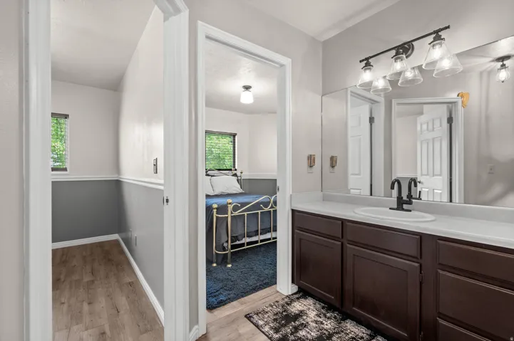 Bathroom vanity with dark wood-finish cabinetry, a white countertop, and an undermount sink