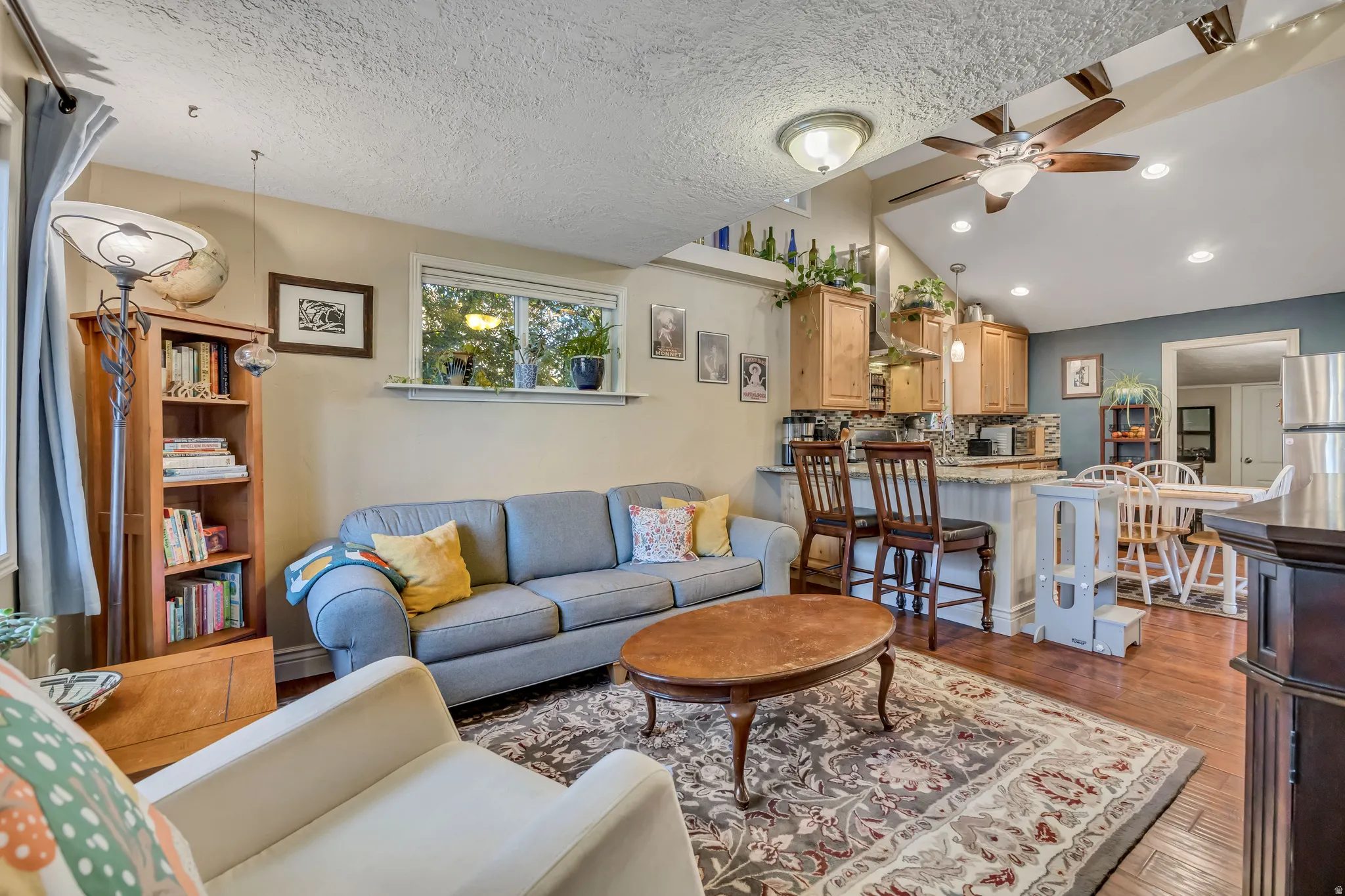 Open-concept living space featuring wood-finish flooring and a vaulted ceiling