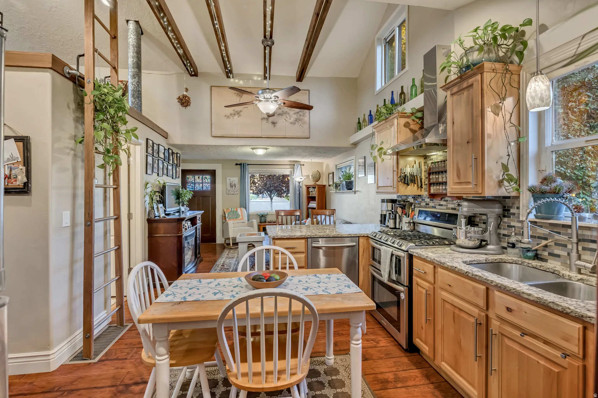Kitchen featuring wood-finish flooring, natural wood cabinetry, stainless steel appliances, granite countertops, and a tiled backsplash
