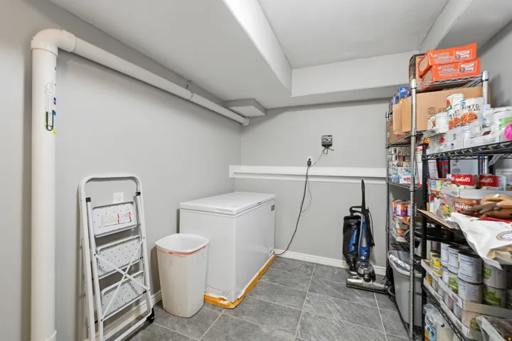 Utility room with gray painted walls, gray tile flooring, and exposed white ceiling beams