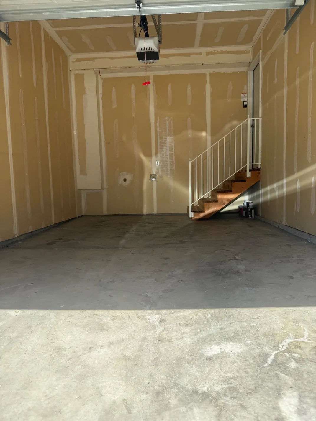 Spacious garage with an automatic door opener and unfinished walls