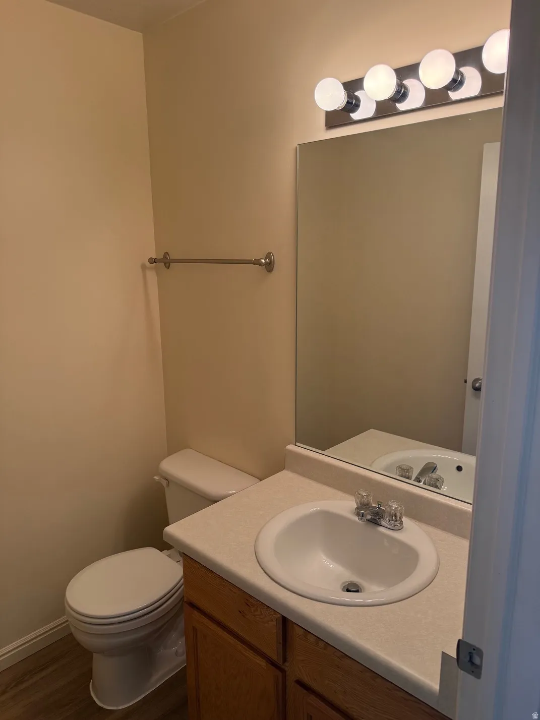 Half bathroom vanity with a laminate countertop, integrated sink, and wood-finish cabinetry