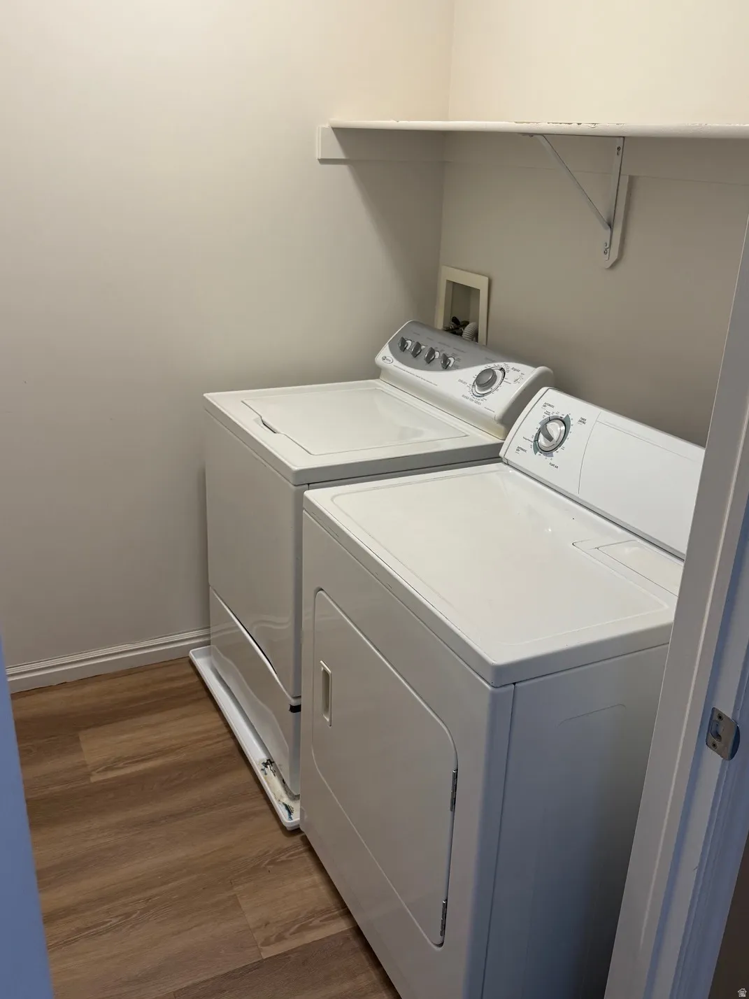 Dedicated laundry area featuring wood-finish flooring