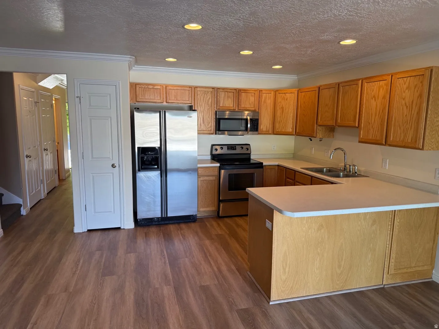 Kitchen featuring wood-finish flooring, recessed lighting, and crown molding