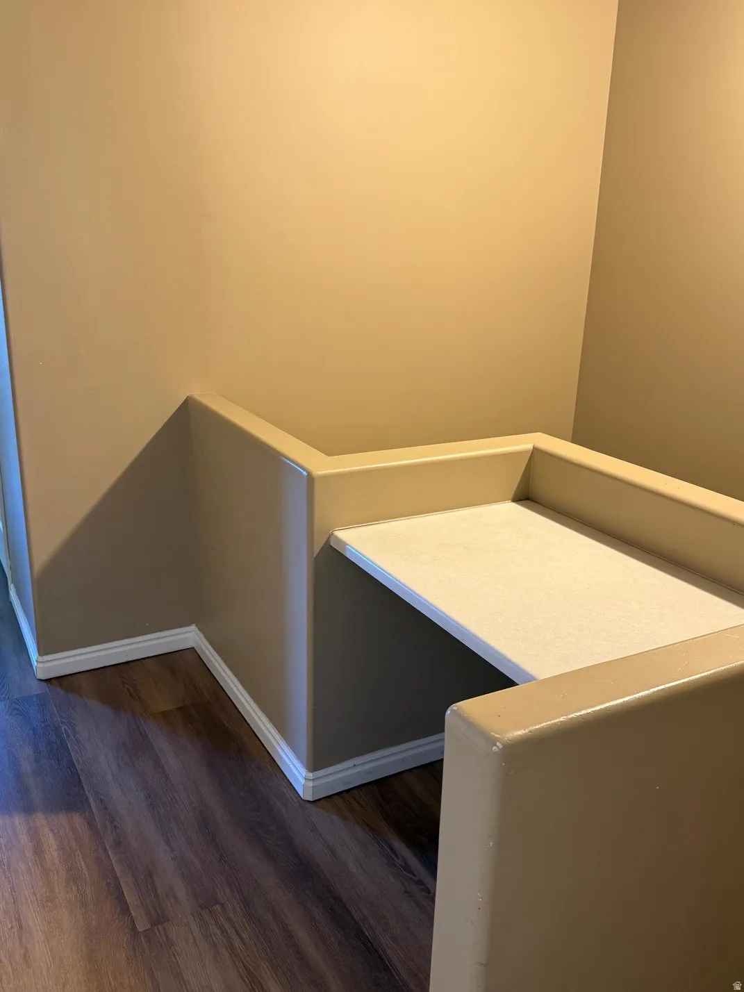 Built-in desk nook with a light-colored countertop and wood-finish flooring