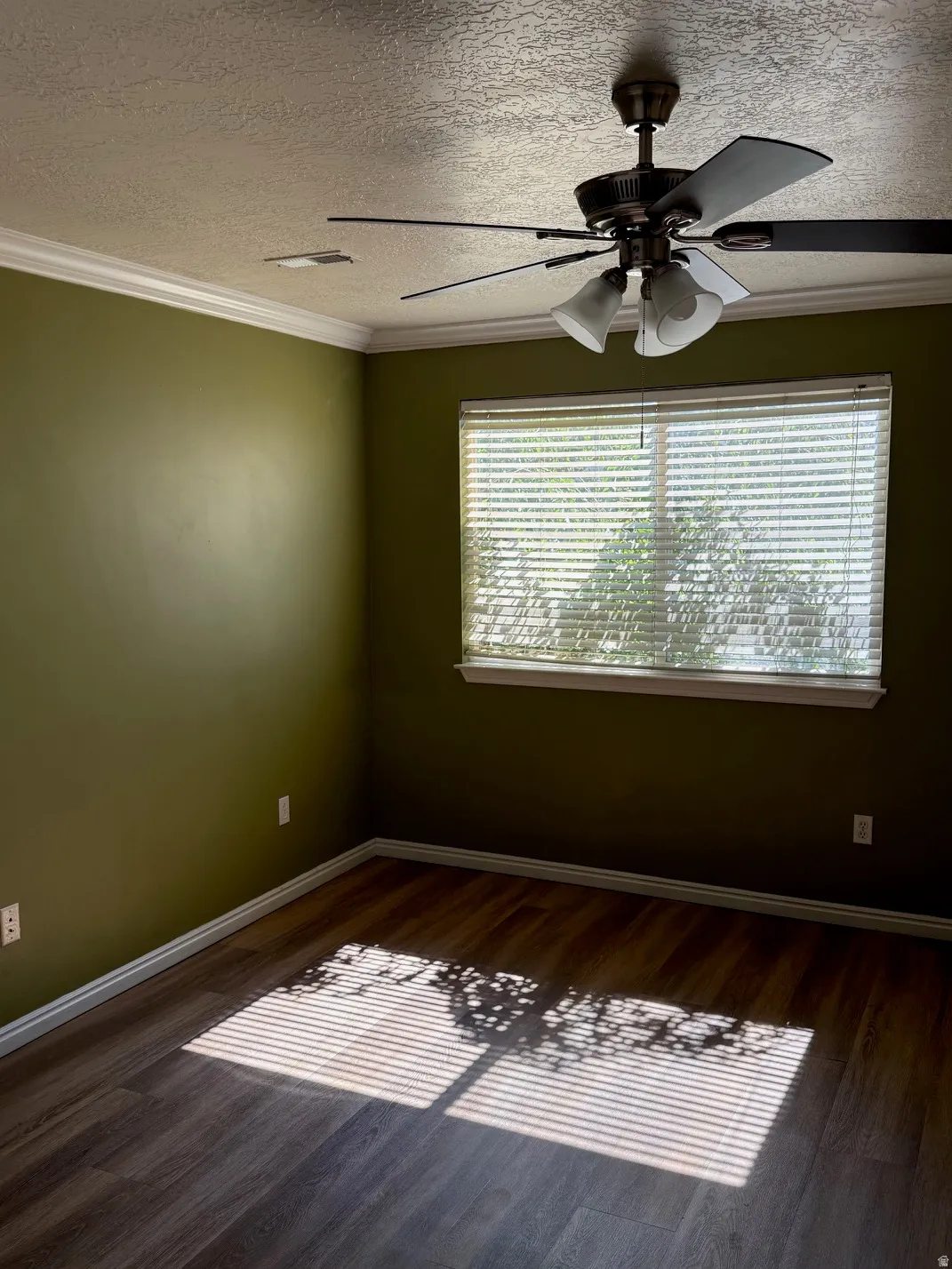 Master Bedroom featuring wood-finish flooring, a window with blinds, crown molding, baseboards, and a ceiling fan with integrated lighting