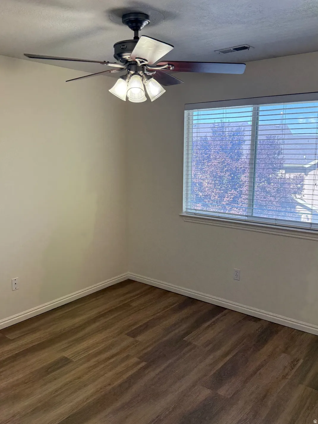 Bedroom featuring wood-finish flooring, white baseboards, and neutral wall tones