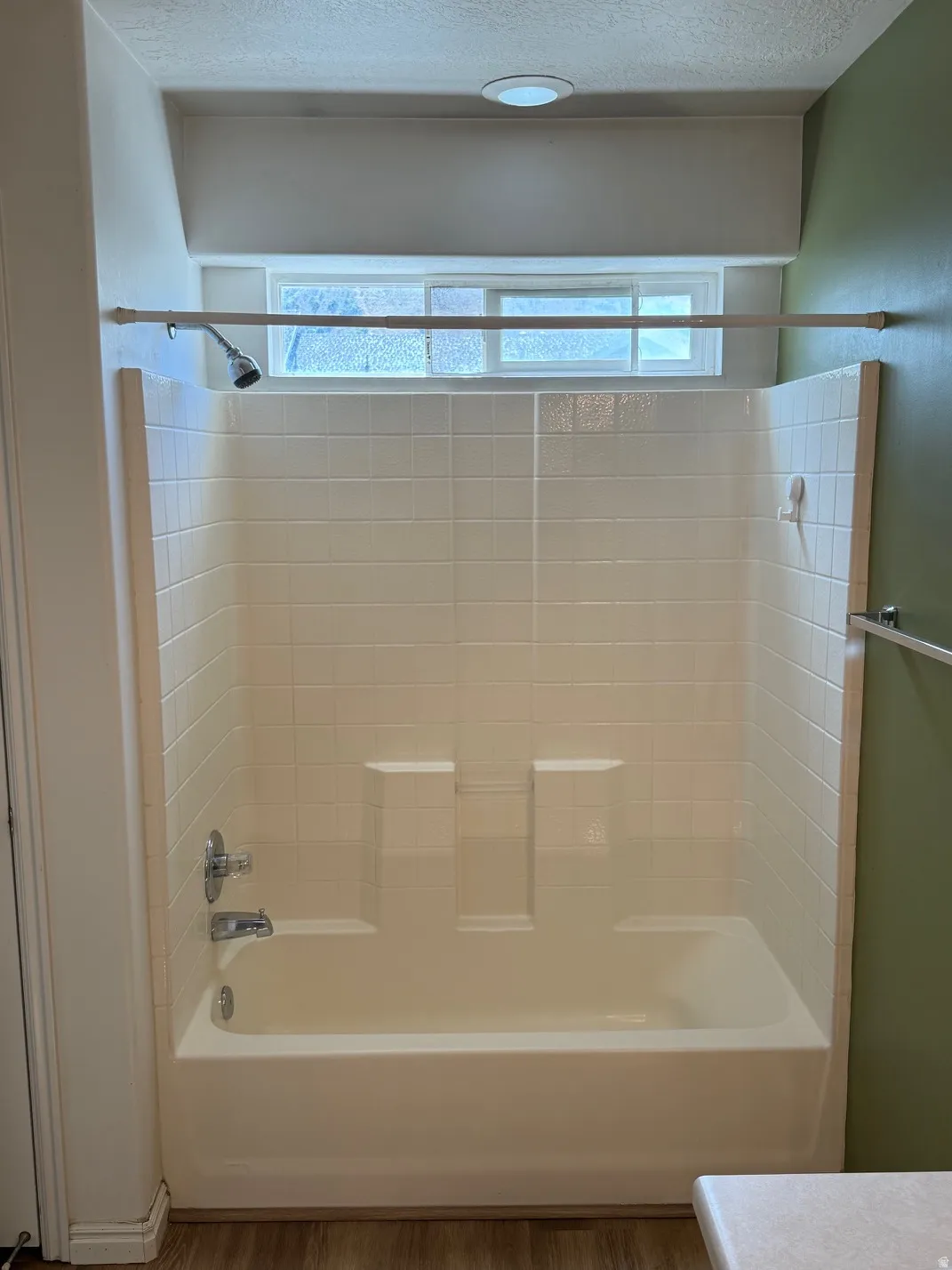 Master Bathtub with integrated shower, chrome fixtures, and a tiled surround