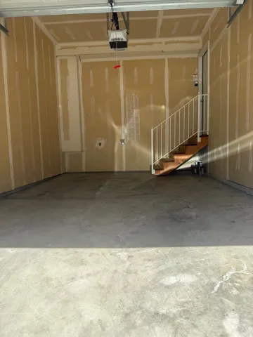 Spacious garage with an automatic door opener and unfinished walls