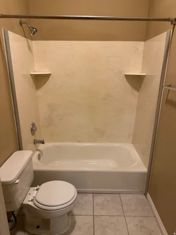White bathtub and shower combination unit with integrated wall panels