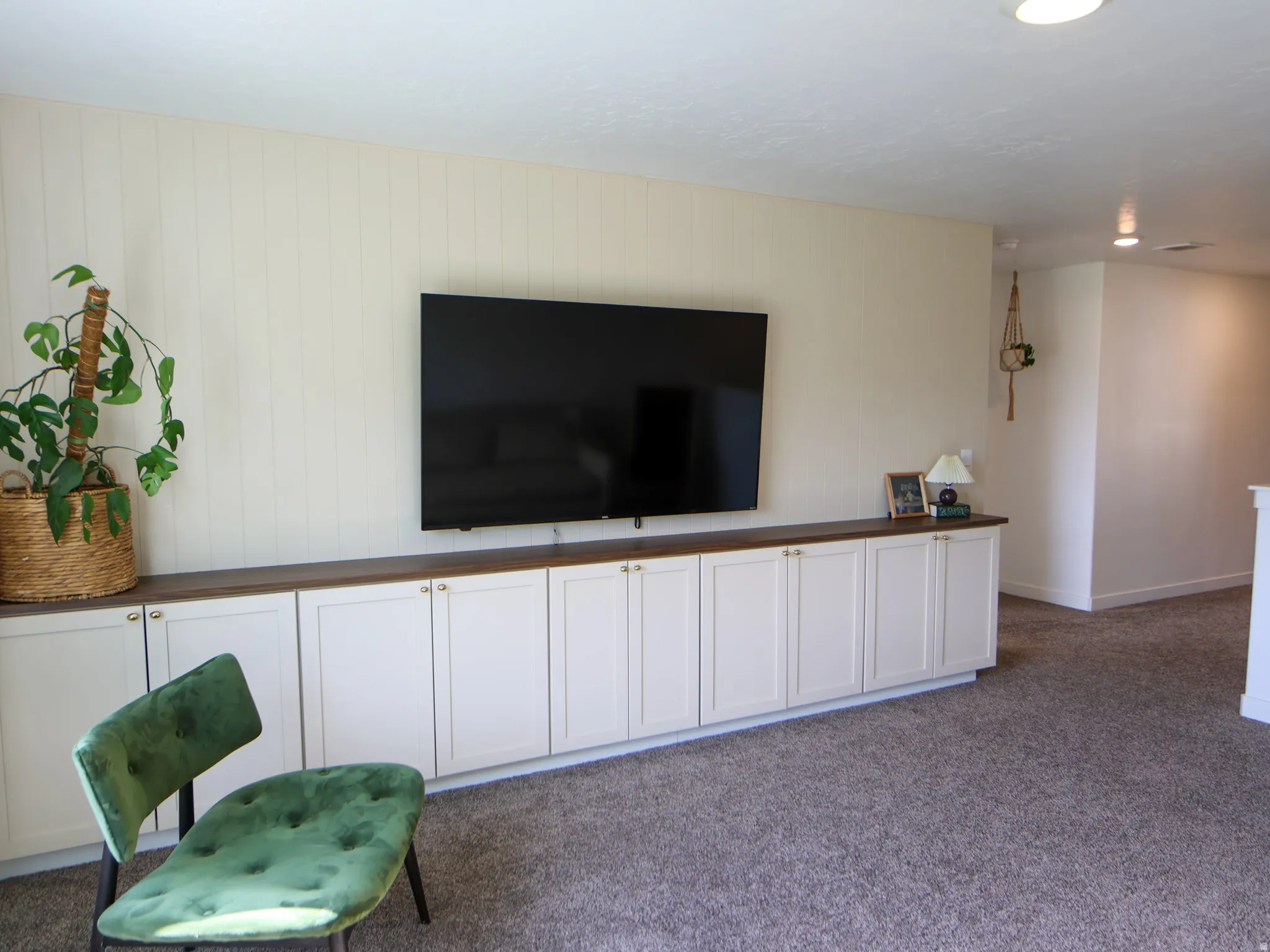 Loft/Living room on 2nd story with built in cabinets and vertical shiplap on wall.
