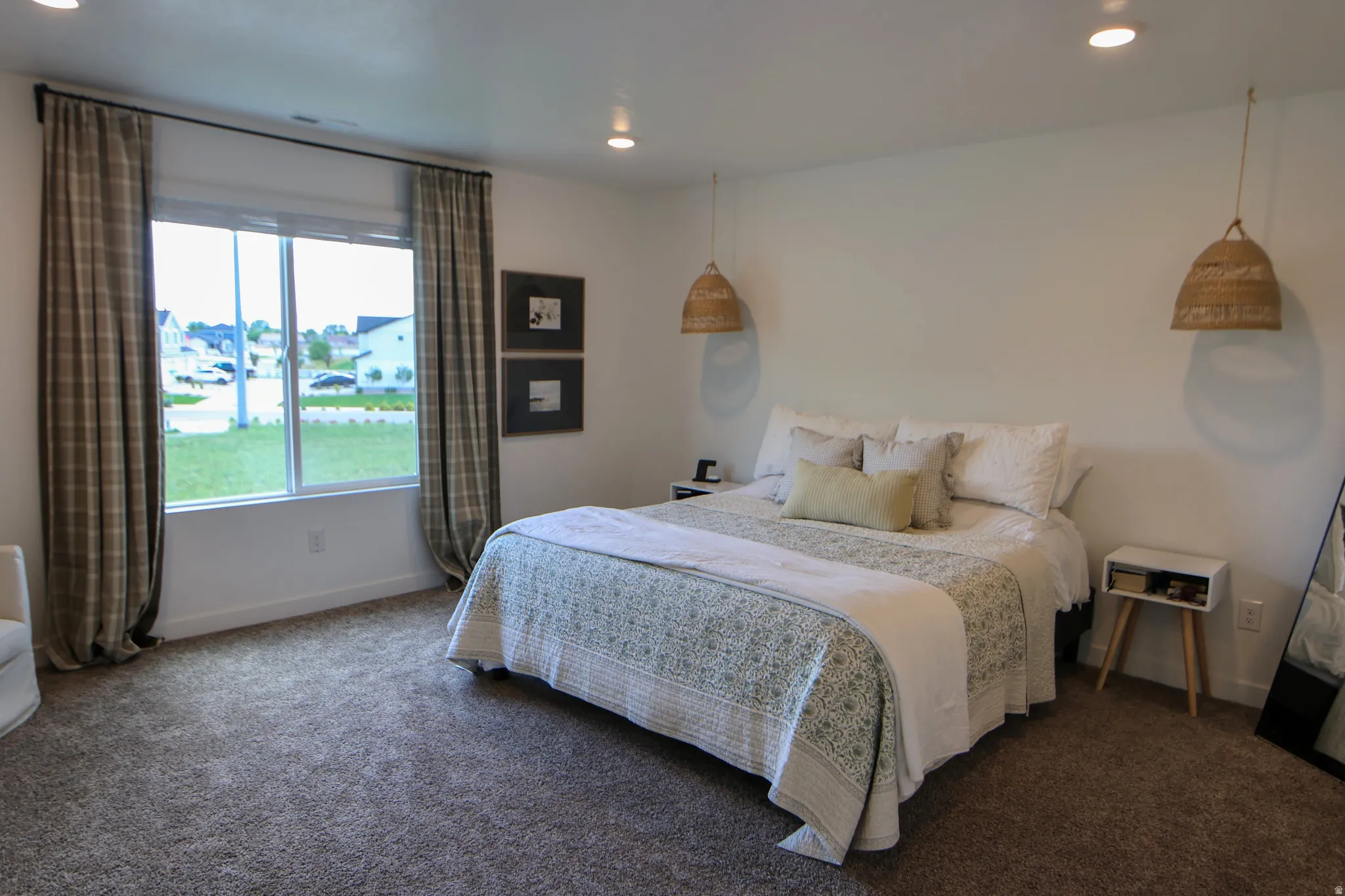 Primary bedroom with large picture window, and recessed lighting