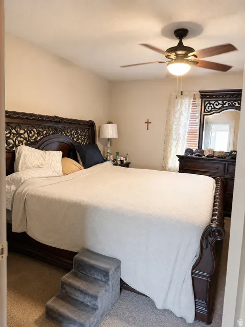 Carpeted room featuring a ceiling fan with integrated lighting