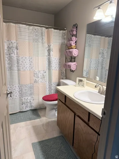 Vanity with wood-finish cabinetry, integrated sink, and light-toned countertop