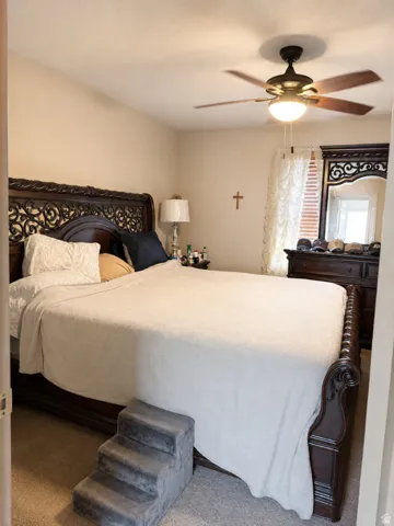 Carpeted room featuring a ceiling fan with integrated lighting