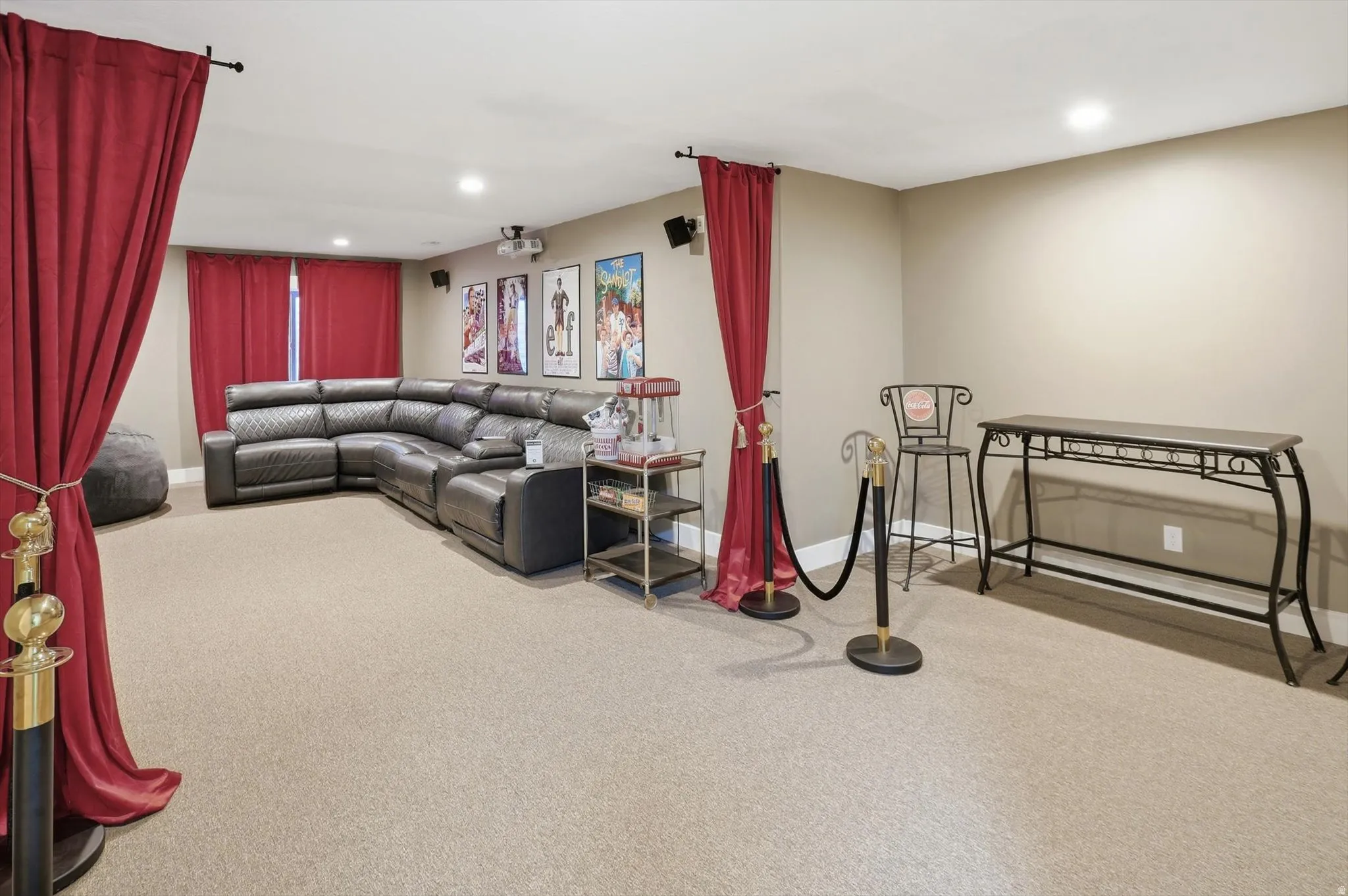 Expansive entertainment space featuring recessed lighting, a large projection screen, and integrated ceiling speakers