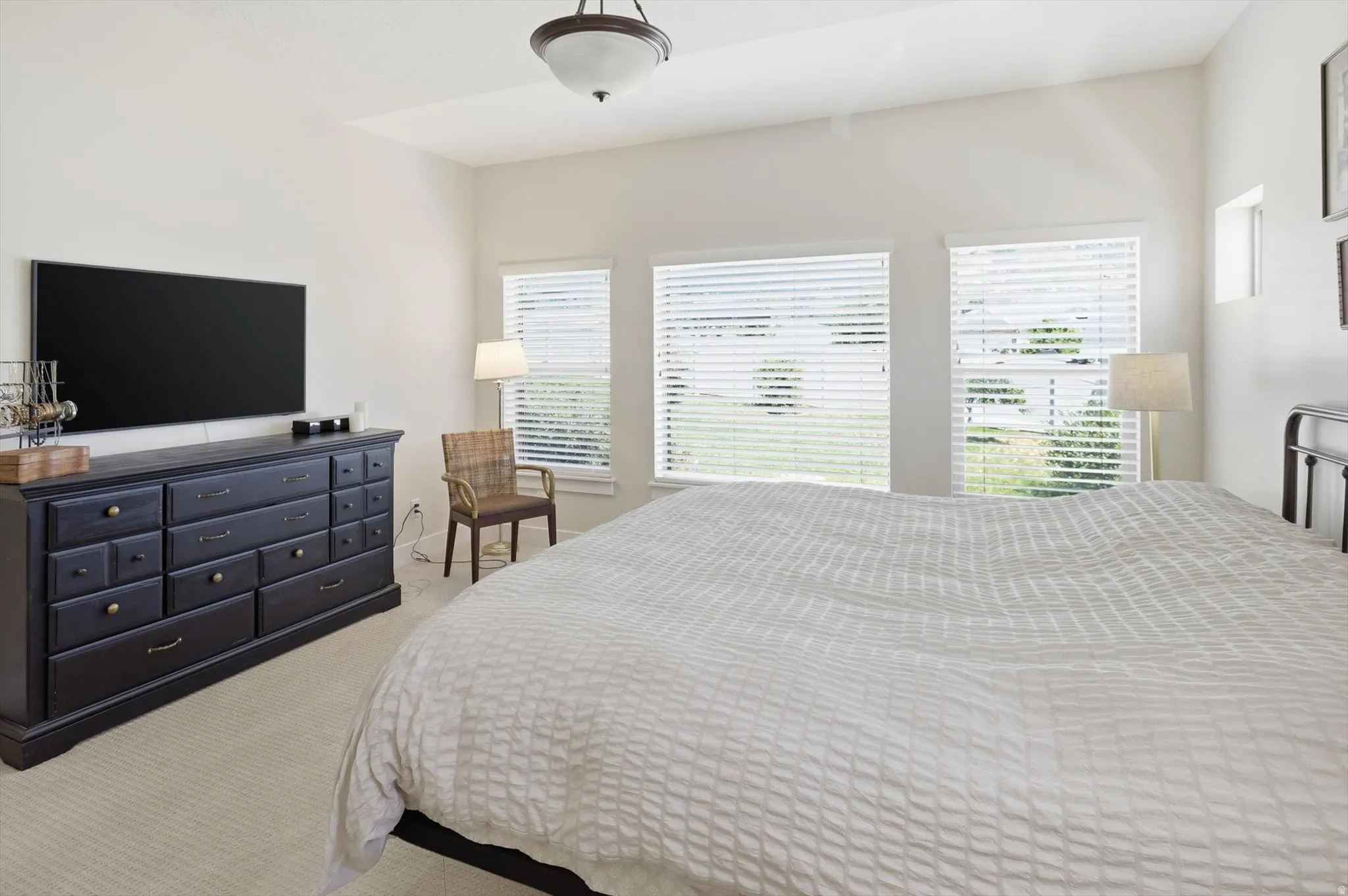 Carpeted room featuring a vaulted ceiling and a semi-flush mount light fixture