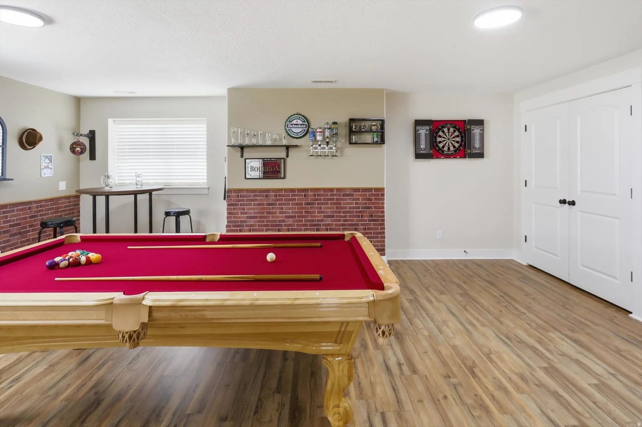 Recreation room featuring wood-finish flooring, a red felt billiard table, recessed lighting, and white bi-fold doors