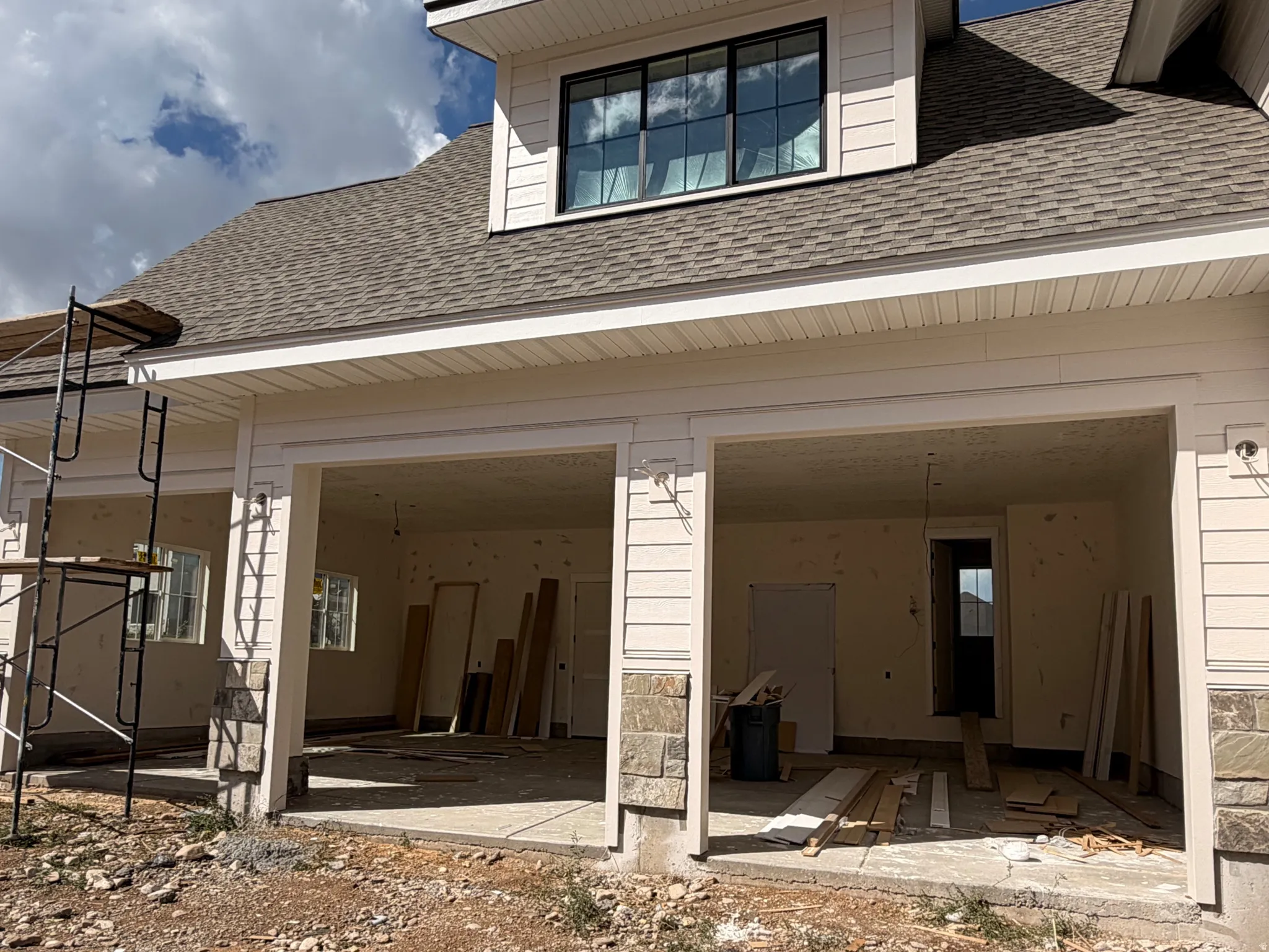 Two-bay garage entry with stone accents and exterior lighting fixtures