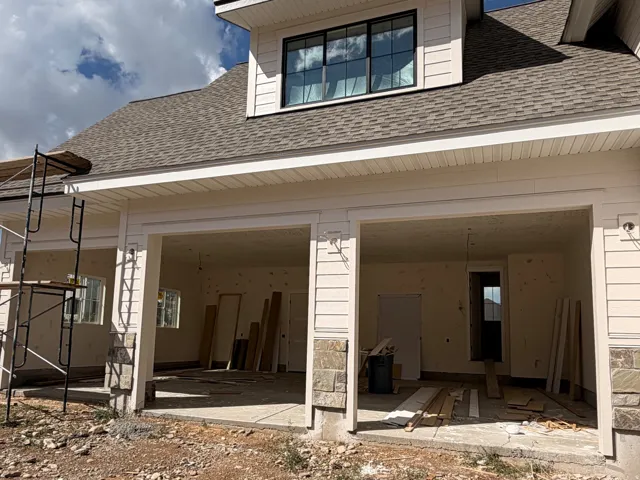 Two-bay garage entry with stone accents and exterior lighting fixtures