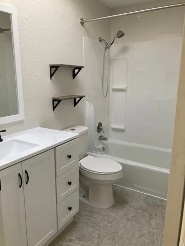 Bathroom featuring a white vanity with integrated sink, matte black hardware, and a white countertop
